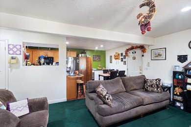 Living area featuring dark colored carpet, recessed lighting, and a textured ceiling
