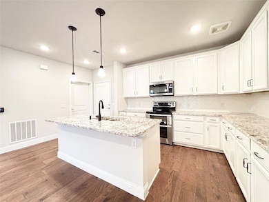 Kitchen with a sink, visible vents, light wood-sty