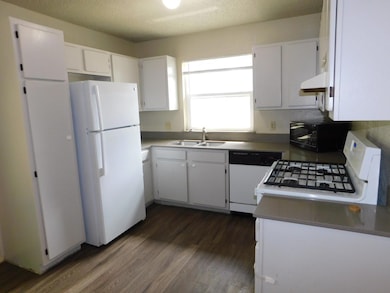 Kitchen featuring a textured ceiling, range hood,
