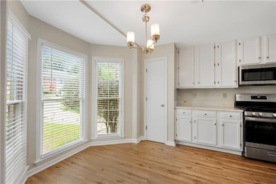 Bright and airy kitchen and dining area featuring large bay windows—perfect for casual dining with natural light.