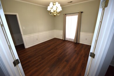 Unfurnished room with crown molding, dark wood-typ