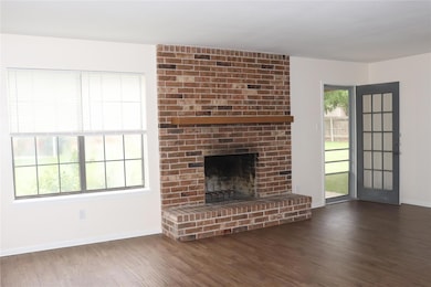 Unfurnished living room featuring a brick firepla