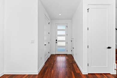 Corridor with dark wood-style floors and recessed