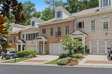 Colonial inspired home featuring an attached garage, driveway, and brick siding