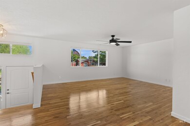 Spare room featuring plenty of natural light, wood finished floors, and a ceiling fan