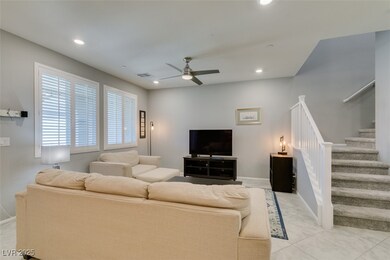 Living area with stairway, a ceiling fan, recessed