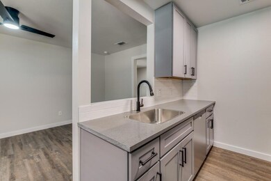 Kitchen featuring backsplash, gray cabinets, light