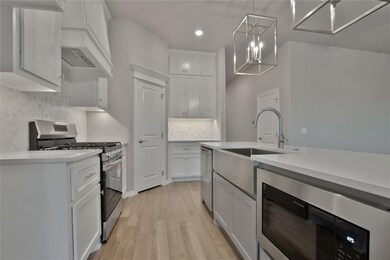 Kitchen featuring tasteful backsplash, custom exhaust hood, stainless steel appliances, light wood-type flooring, and pendant lighting