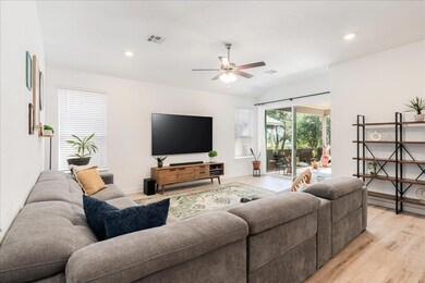 Living area featuring a ceiling fan, light wood-t