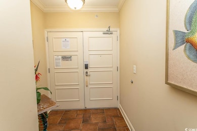 Entryway featuring ornamental molding and dark stone finish floors