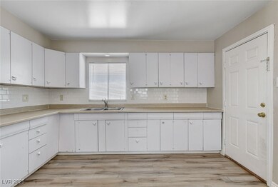 Kitchen featuring white cabinets, and light counte