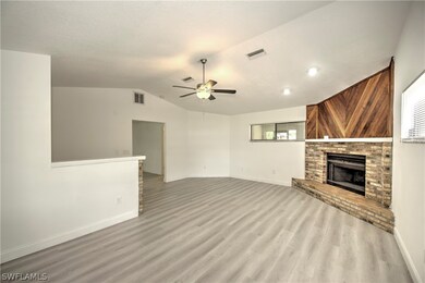 Unfurnished living room featuring a brick fireplac