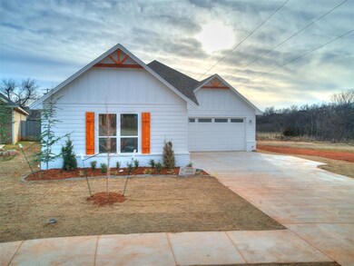 View of front of home with a garage, driveway, roo