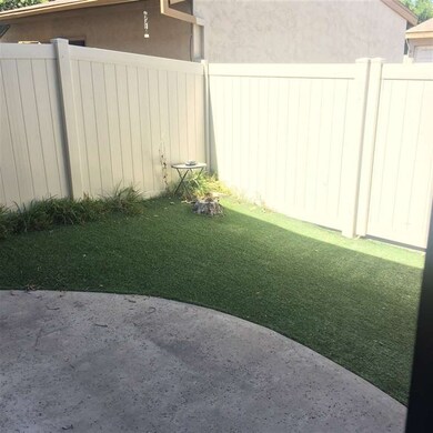 Back patio with artificial grass leading to garage