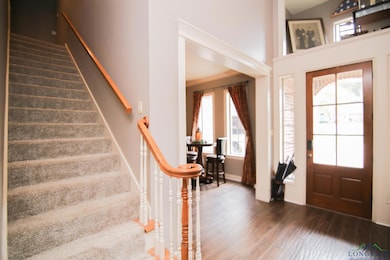 Entrance foyer with baseboards, dark wood-style fl