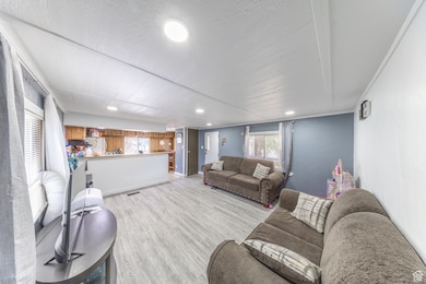 Living room featuring light wood-style floors and a textured ceiling