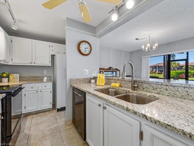 Kitchen with a sink, white cabinets, black appliances, and rail lighting