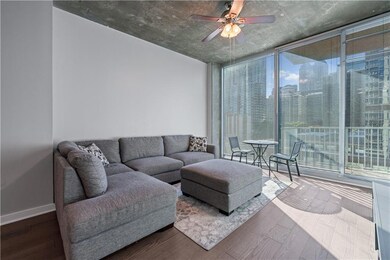 Living area featuring floor to ceiling windows, wood finished floors, and a ceiling fan