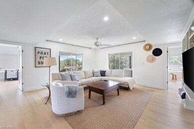 Living area with light wood finished floors, healthy amount of natural light, baseboards, a textured ceiling, and recessed lighting