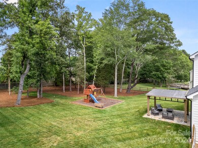 The large, fenced rear yard offers ample room for a pool. Pergola and Play structure to convey.