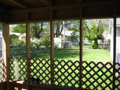 View to the fenced back yard from the screened por