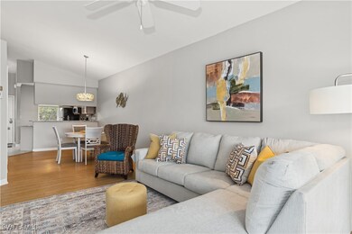 Living room with vaulted ceiling, ceiling fan, and hardwood / wood-style flooring