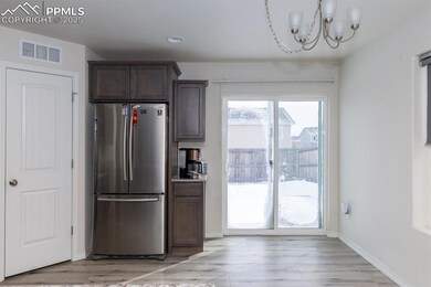 Kitchen with stainless steel fridge, dark brown ca