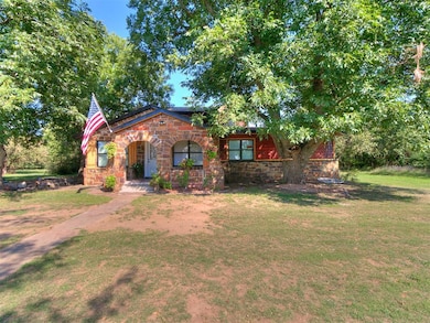 View of front of property featuring stone siding, a porch, and a front yard