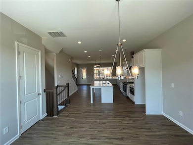Kitchen with white cabinetry, recessed lighting, an island with sink, dark wood-style floors, and open floor plan