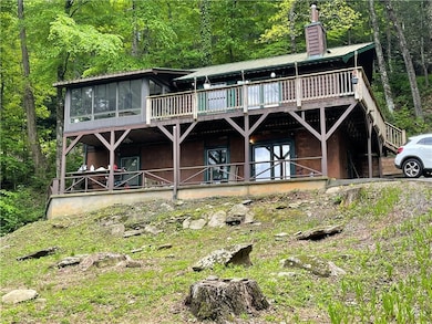 Rear view of property with a chimney, a sunroom, a
