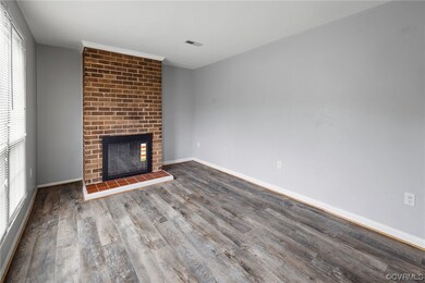 LVP flooring in living room featuring a brick fire