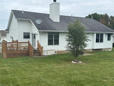 Back of property with a deck and a lawn