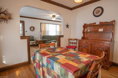 Formal dining room with wood flooring, crown moldi