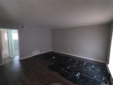 Unfurnished room featuring visible vents, baseboar