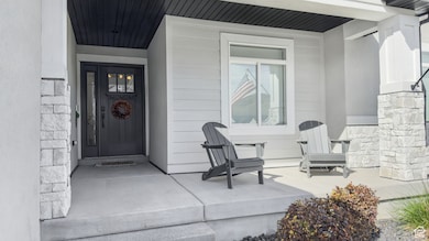 Doorway to property with stone siding and covered porch
