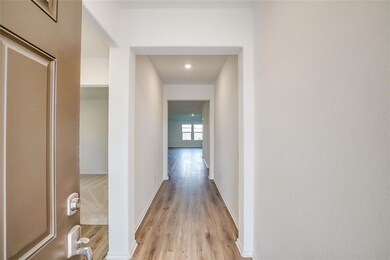 Corridor with light wood-style floors and baseboa