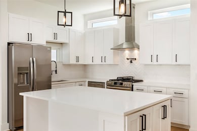 This is a modern kitchen featuring white cabinetry