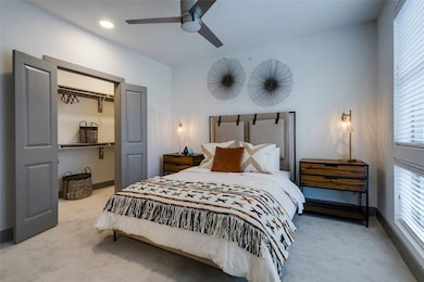 Bedroom with light carpet and a ceiling fan