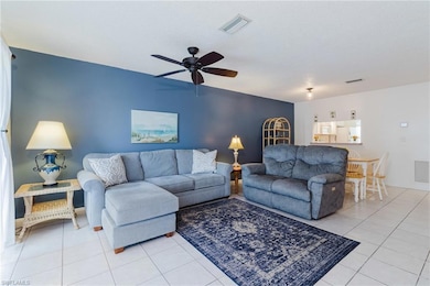 Living room featuring visible vents, ceiling fan, 