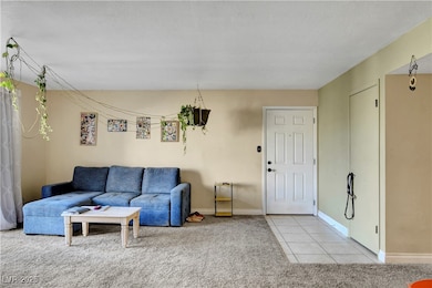 Living area featuring light carpet and light tile patterned floors