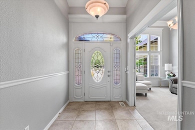 Entrance foyer featuring a textured wall and light tile patterned floors