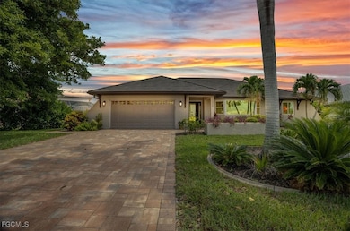 View of front facade featuring stucco siding, a garage, decorative driveway, and a front yard