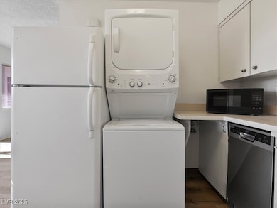 Laundry room with stacked washer / dryer and dark