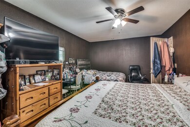 Bedroom featuring ceiling fan, a textured ceiling,