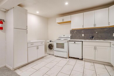 Kitchen with white cabinetry, white appliances, wa