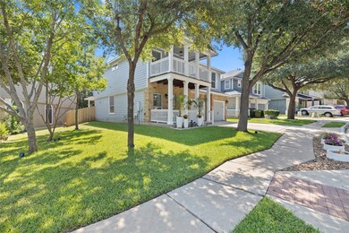 View of front of home featuring concrete driveway, an attached garage, a balcony, a porch, and stone siding