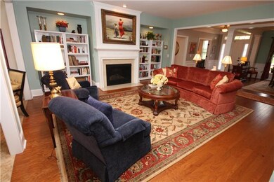 The great room is open to the living areas of the house.  It features a fireplace. Hardwood flooring flows throughout. 