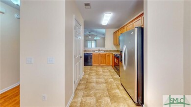 Peek into kitchen with pantry and neutral cabinets