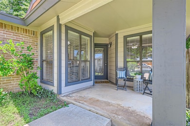 Doorway to property featuring a porch and brick s