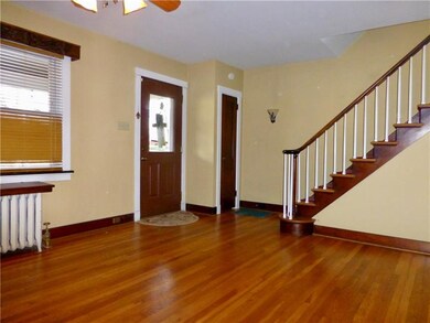 Living room has hardwood floors and runner on stai